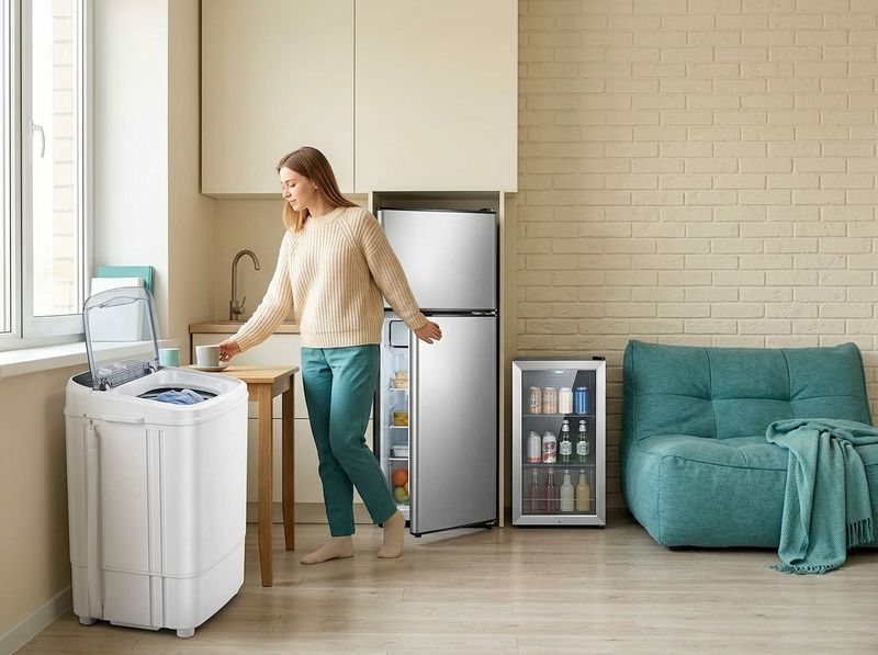 Dorm fridge open in a desk corner with frozen meals and produce
